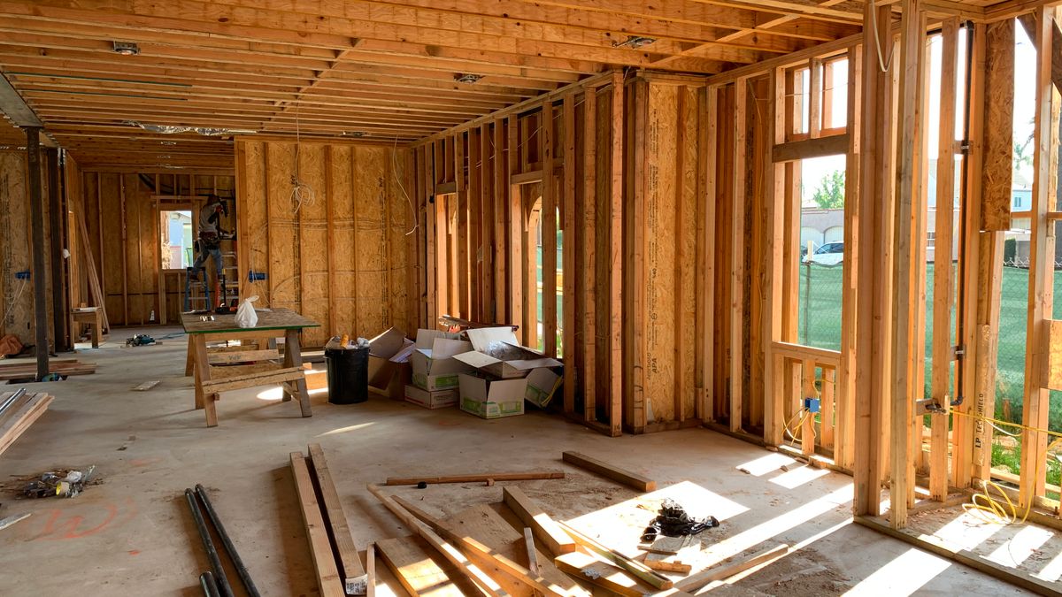 Intérieur baigné de lumière montrant l'ossature bois d'un plancher à l'étage en cours de rénovation